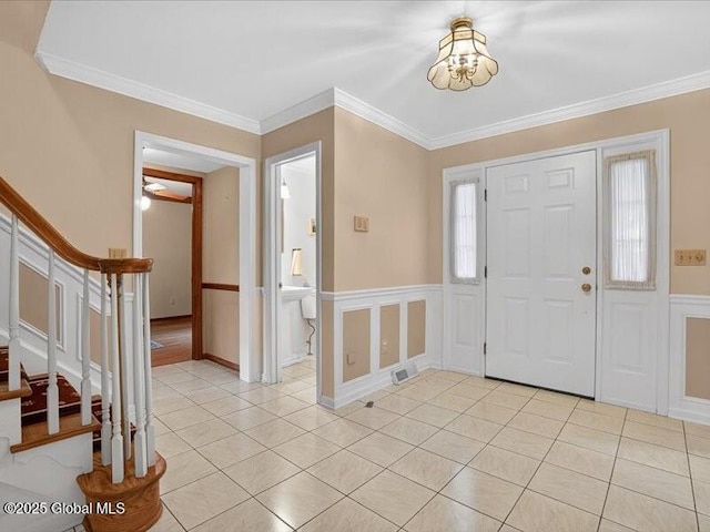 3077 New Williamsburg Dr, Guilderland, NY 12303 - entrance foyer with crown molding, stairway, light tile patterned floors, a chandelier, and a wainscoted wall