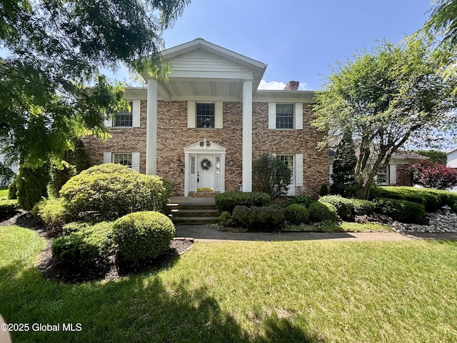 3077 New Williamsburg Dr, Guilderland, NY 12303 - greek revival house featuring a front yard, a chimney, and brick siding