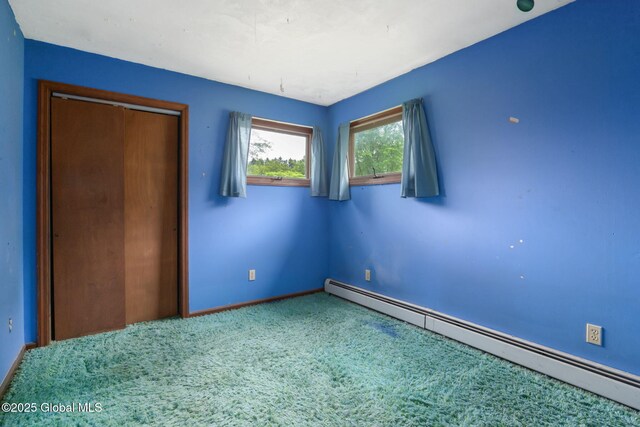 195 N St, Cobleskill, NY 12043 - unfurnished bedroom featuring a baseboard heating unit, carpet flooring, a closet, and baseboards
