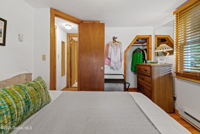 858 E River Dr, Lake Luzerne, NY 12846 - bedroom with a baseboard heating unit, wood finished floors, and a walk in closet