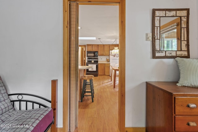 858 E River Dr, Lake Luzerne, NY 12846 - corridor with light wood-style flooring, a chandelier, and plenty of natural light