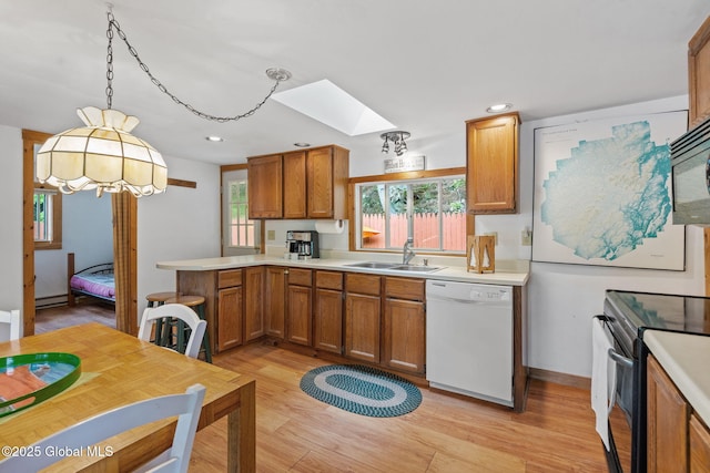 858 E River Dr, Lake Luzerne, NY 12846 - kitchen with black appliances, a sink, a skylight, a peninsula, and brown cabinets