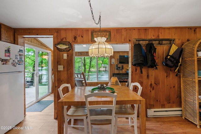 858 E River Dr, Lake Luzerne, NY 12846 - dining area featuring baseboard heating, plenty of natural light, and wooden walls