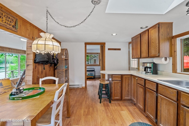 858 E River Dr, Lake Luzerne, NY 12846 - kitchen featuring baseboard heating, a peninsula, light wood-style floors, brown cabinets, and recessed lighting