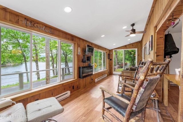 858 E River Dr, Lake Luzerne, NY 12846 - living area featuring a baseboard radiator, vaulted ceiling, a ceiling fan, wooden walls, and light wood-type flooring
