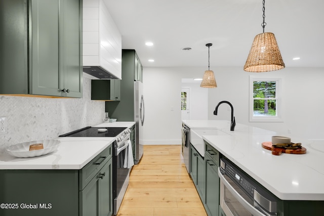 106 E Berkley Sq, Glenville, NY 12302 - kitchen with stainless steel appliances, green cabinets, light wood-style flooring, backsplash, and recessed lighting