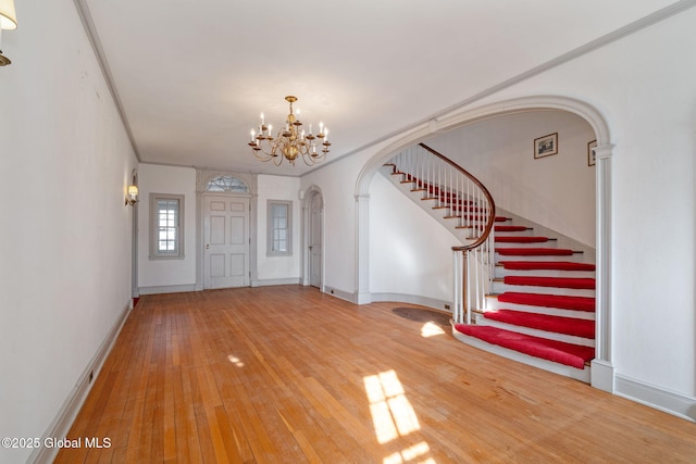 2125 Rosendale Rd, Niskayuna, NY 12309 - foyer entrance featuring arched walkways, a chandelier, stairs, hardwood / wood-style flooring, and baseboards