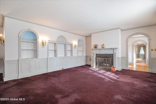 2125 Rosendale Rd, Niskayuna, NY 12309 - unfurnished living room featuring carpet, crown molding, a high end fireplace, arched walkways, and a wainscoted wall