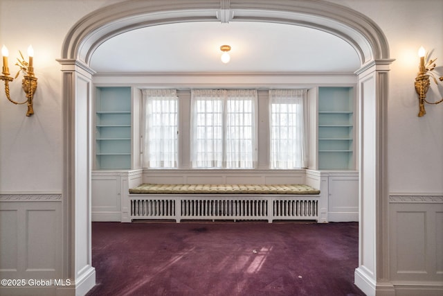 2125 Rosendale Rd, Niskayuna, NY 12309 - empty room with radiator heating unit, wainscoting, dark colored carpet, built in features, and a decorative wall