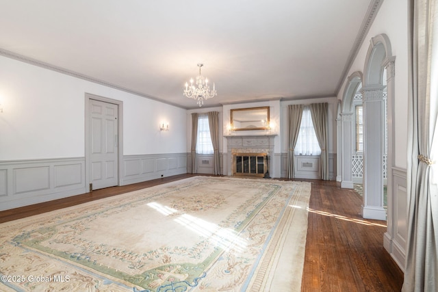 2125 Rosendale Rd, Niskayuna, NY 12309 - unfurnished living room featuring ornamental molding, a chandelier, dark wood finished floors, a decorative wall, and a fireplace