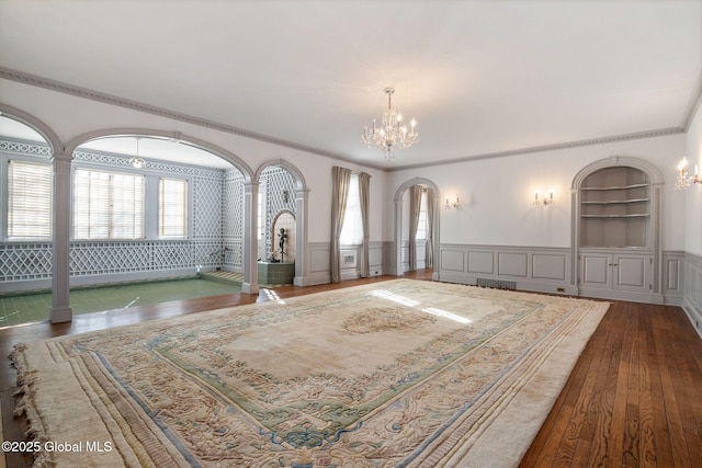 2125 Rosendale Rd, Niskayuna, NY 12309 - living room with a chandelier, arched walkways, hardwood / wood-style floors, ornamental molding, and a decorative wall