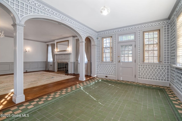 2125 Rosendale Rd, Niskayuna, NY 12309 - entrance foyer featuring ornate columns, crown molding, a wainscoted wall, a decorative wall, and arched walkways