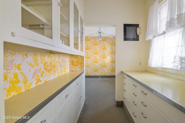 2125 Rosendale Rd, Niskayuna, NY 12309 - kitchen featuring wallpapered walls, white cabinets, ceiling fan, glass insert cabinets, and baseboards