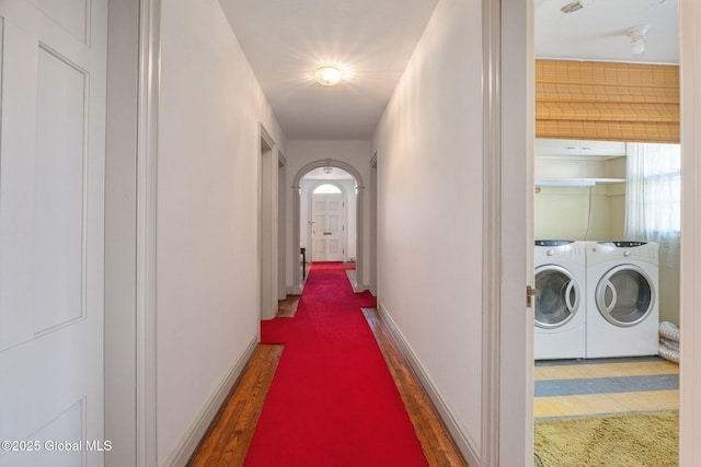 2125 Rosendale Rd, Niskayuna, NY 12309 - hallway featuring washing machine and clothes dryer, arched walkways, wood finished floors, and baseboards