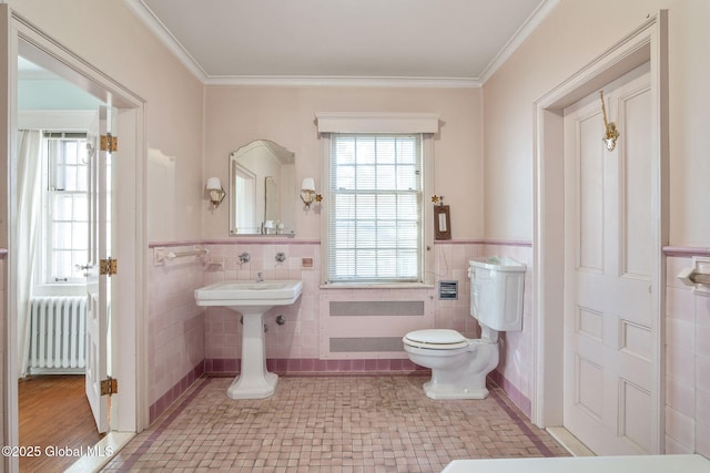 2125 Rosendale Rd, Niskayuna, NY 12309 - half bathroom featuring radiator heating unit, tile walls, radiator, toilet, and a wainscoted wall