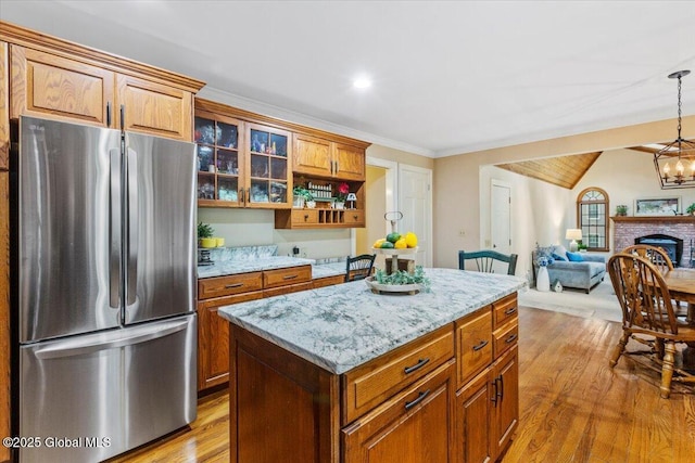 19 Canterbury Rd, Clifton Park, NY 12065 - kitchen with freestanding refrigerator, light wood-style floors, a kitchen island, light stone counters, and glass insert cabinets