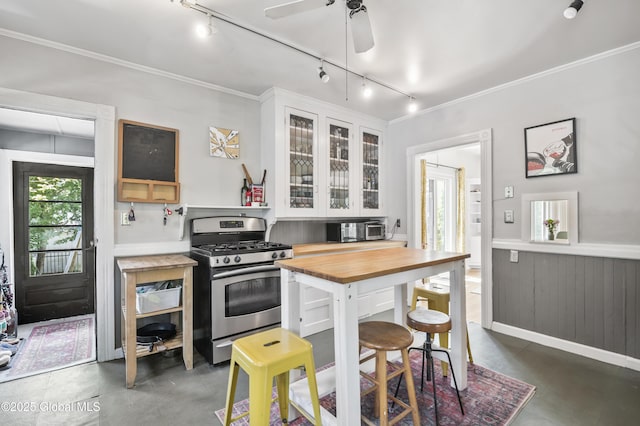 30 Monument Ave, Glens Falls, NY 12801 - kitchen featuring stainless steel gas range oven, track lighting, finished concrete floors, white cabinetry, and glass insert cabinets