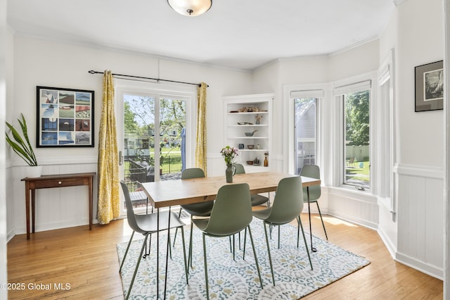 30 Monument Ave, Glens Falls, NY 12801 - dining room with light wood finished floors, wainscoting, crown molding, and a decorative wall