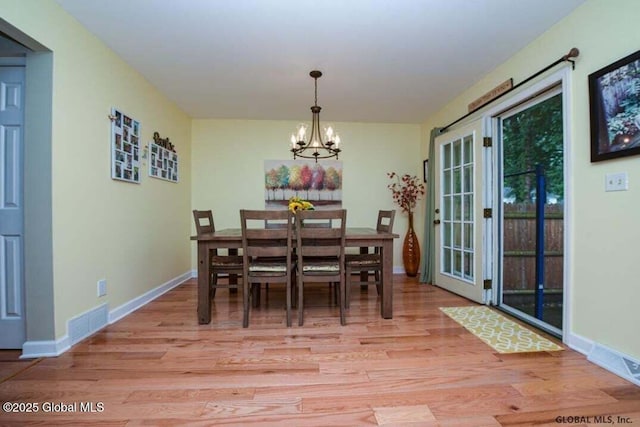198 Williamsburg Ct, Albany, NY 12203 - dining area with light wood-style floors, a chandelier, and baseboards