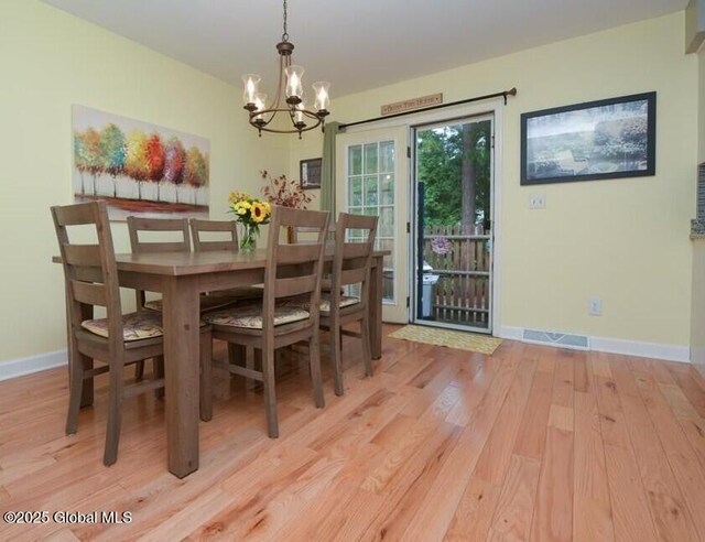 198 Williamsburg Ct, Albany, NY 12203 - dining space with light wood-style floors, a chandelier, and baseboards