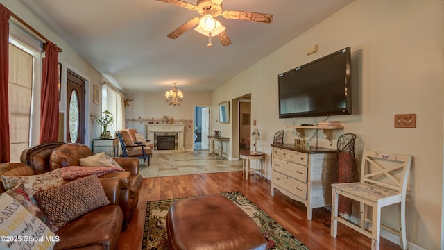 127 Firefly Meadow Rd, Glen, NY 12072 - living area with wood finished floors, ceiling fan, a chandelier, and a glass covered fireplace
