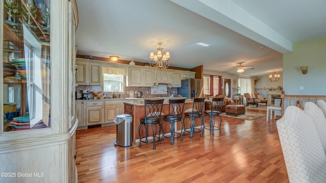 127 Firefly Meadow Rd, Glen, NY 12072 - kitchen featuring a chandelier, stainless steel fridge, cream cabinets, open floor plan, and wainscoting
