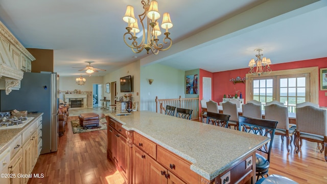 127 Firefly Meadow Rd, Glen, NY 12072 - kitchen featuring a chandelier, a glass covered fireplace, light wood-style flooring, and open floor plan