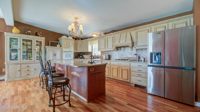 127 Firefly Meadow Rd, Glen, NY 12072 - kitchen with stainless steel fridge, white oven, cream cabinetry, premium range hood, and light wood finished floors