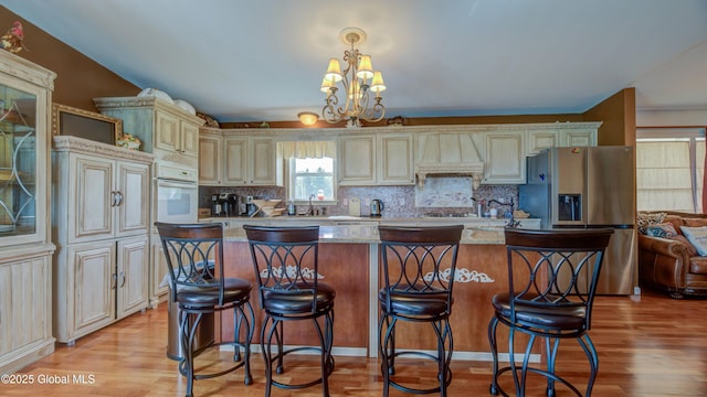 127 Firefly Meadow Rd, Glen, NY 12072 - kitchen featuring cream cabinets, premium range hood, stainless steel fridge, white oven, and light wood-style floors