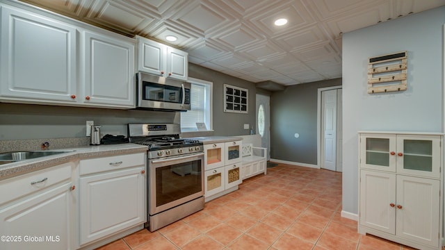 127 Firefly Meadow Rd, Glen, NY 12072 - kitchen with stainless steel appliances, light countertops, white cabinets, light tile patterned floors, and a sink