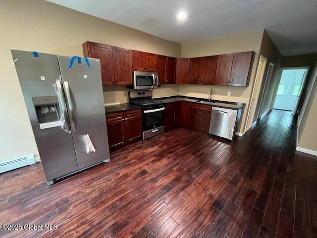 201 10th St, Troy, NY 12180 - kitchen featuring appliances with stainless steel finishes, dark wood-type flooring, dark countertops, a baseboard heating unit, and a sink