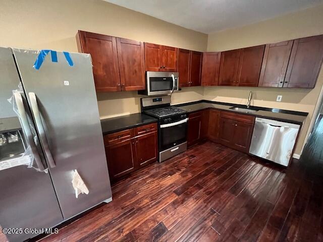 201 10th St, Troy, NY 12180 - kitchen featuring appliances with stainless steel finishes, dark wood-style flooring, dark countertops, and a sink