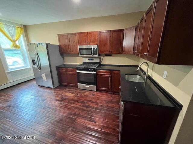 201 10th St, Troy, NY 12180 - kitchen featuring appliances with stainless steel finishes, a sink, dark countertops, and dark wood-type flooring