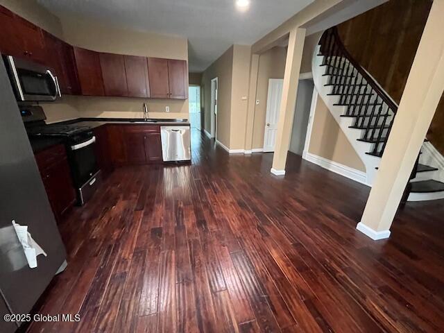 201 10th St, Troy, NY 12180 - kitchen with appliances with stainless steel finishes, dark wood finished floors, a sink, and baseboards