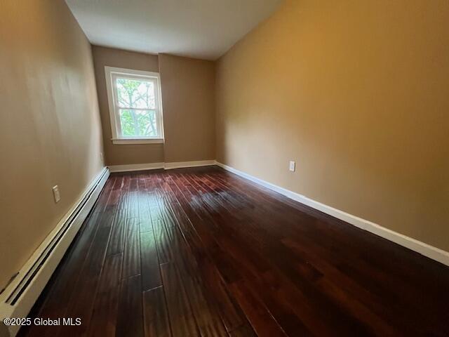 201 10th St, Troy, NY 12180 - unfurnished room with a baseboard heating unit, dark wood finished floors, and baseboards