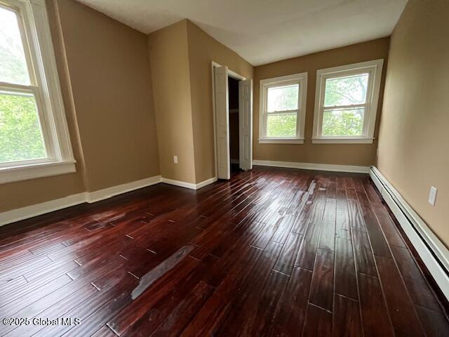 201 10th St, Troy, NY 12180 - spare room featuring a baseboard radiator, healthy amount of natural light, dark wood-type flooring, and baseboards