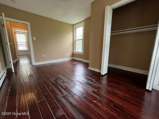 201 10th St, Troy, NY 12180 - unfurnished bedroom with dark wood-style floors and multiple windows