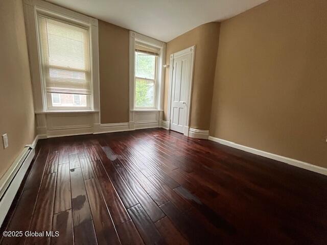 201 10th St, Troy, NY 12180 - spare room with a baseboard heating unit, dark wood finished floors, and baseboards