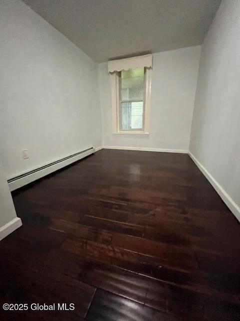 201 10th St, Troy, NY 12180 - spare room featuring baseboard heating, wood finished floors, and baseboards