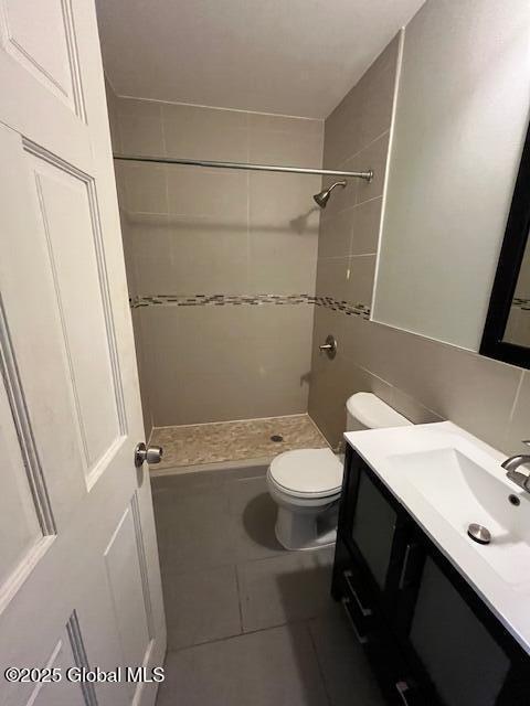 201 10th St, Troy, NY 12180 - full bathroom with a stall shower, vanity, toilet, tile patterned floors, and tile walls