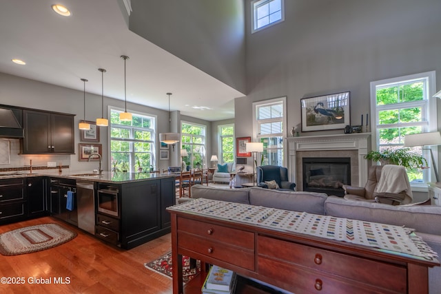 26 Galleon Dr Unit 26, Malta, NY 12020 - kitchen with light wood-style flooring, appliances with stainless steel finishes, a sink, a glass covered fireplace, and recessed lighting