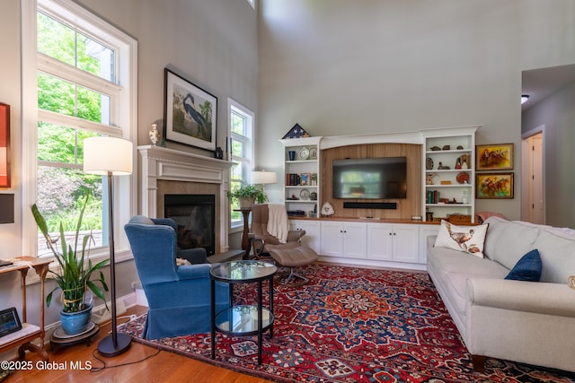 26 Galleon Dr Unit 26, Malta, NY 12020 - living room featuring wood finished floors, a high ceiling, healthy amount of natural light, and a fireplace