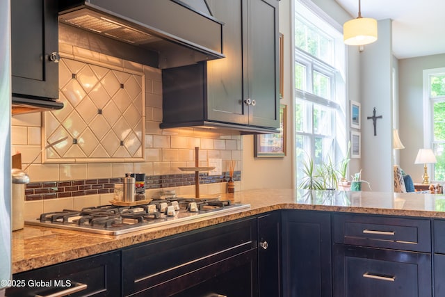 26 Galleon Dr Unit 26, Malta, NY 12020 - kitchen featuring stainless steel gas stovetop, custom range hood, backsplash, light stone counters, and hanging light fixtures
