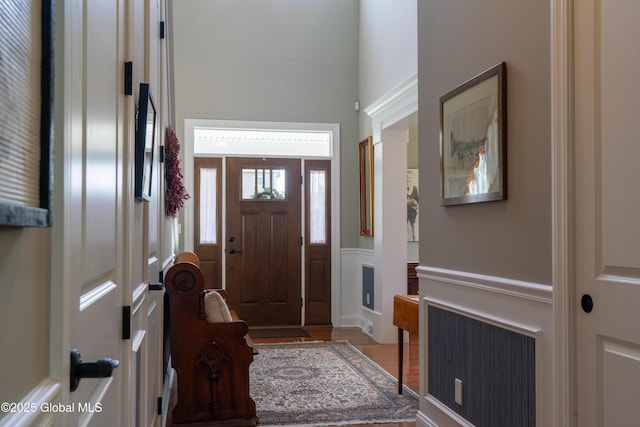 26 Galleon Dr Unit 26, Malta, NY 12020 - foyer featuring wainscoting, a high ceiling, wood finished floors, and a decorative wall