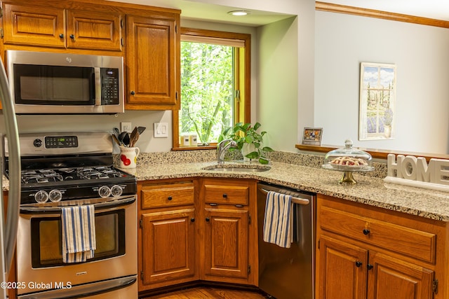 844 Red Oak Dr, Niskayuna, NY 12309 - kitchen with appliances with stainless steel finishes, a sink, light stone countertops, and brown cabinetry