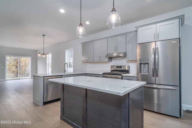 16 Priddle Ln, Colonie, NY 12110 - kitchen featuring appliances with stainless steel finishes, under cabinet range hood, a peninsula, decorative backsplash, and light wood-style flooring