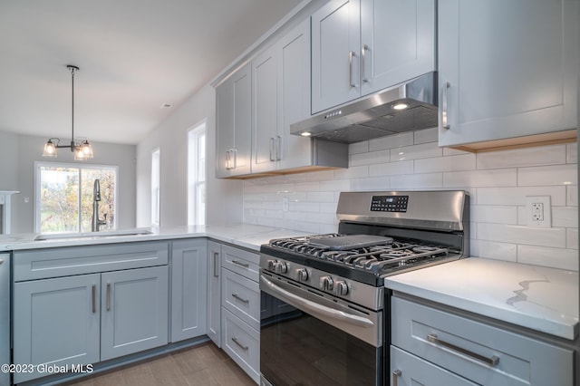 16 Priddle Ln, Colonie, NY 12110 - kitchen featuring gas stove, under cabinet range hood, a sink, tasteful backsplash, and light stone counters
