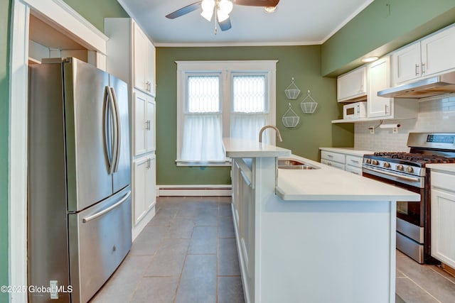 1348 Union St, Schenectady, NY 12308 - kitchen with appliances with stainless steel finishes, under cabinet range hood, a baseboard heating unit, tasteful backsplash, and a ceiling fan