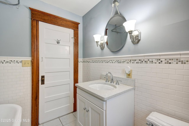 1348 Union St, Schenectady, NY 12308 - bathroom with tile walls, wainscoting, toilet, tile patterned floors, and vanity