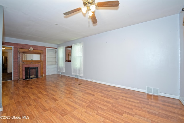 1526 6th Ave, Watervliet, NY 12189 - unfurnished living room featuring ceiling fan, light wood finished floors, and a fireplace